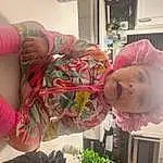 Nose, Skin, Joint, Mouth, Green, Plant, Textile, Dress, Baby, Pink, Toddler, Child, Smile, Houseplant, Fun, Baby & Toddler Clothing, Room, Thumb, Person