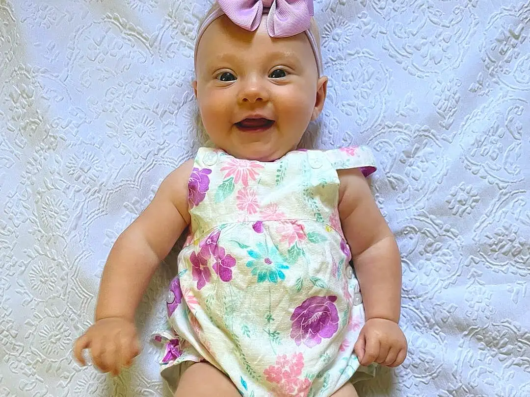 Face, Cheek, Skin, Head, Lip, Arm, Eyes, Dress, Human Body, Baby & Toddler Clothing, Neck, Sleeve, Iris, Pink, Baby, Toddler, Happy, Thumb, Child, Thigh, Person