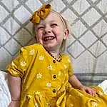Face, Smile, Head, Outerwear, Hairstyle, Facial Expression, Happy, Sleeve, Yellow, Toddler, Fun, Child, Fashion Design, Baby & Toddler Clothing, Event, Tradition, Baby, Pattern, T-shirt, Person, Joy