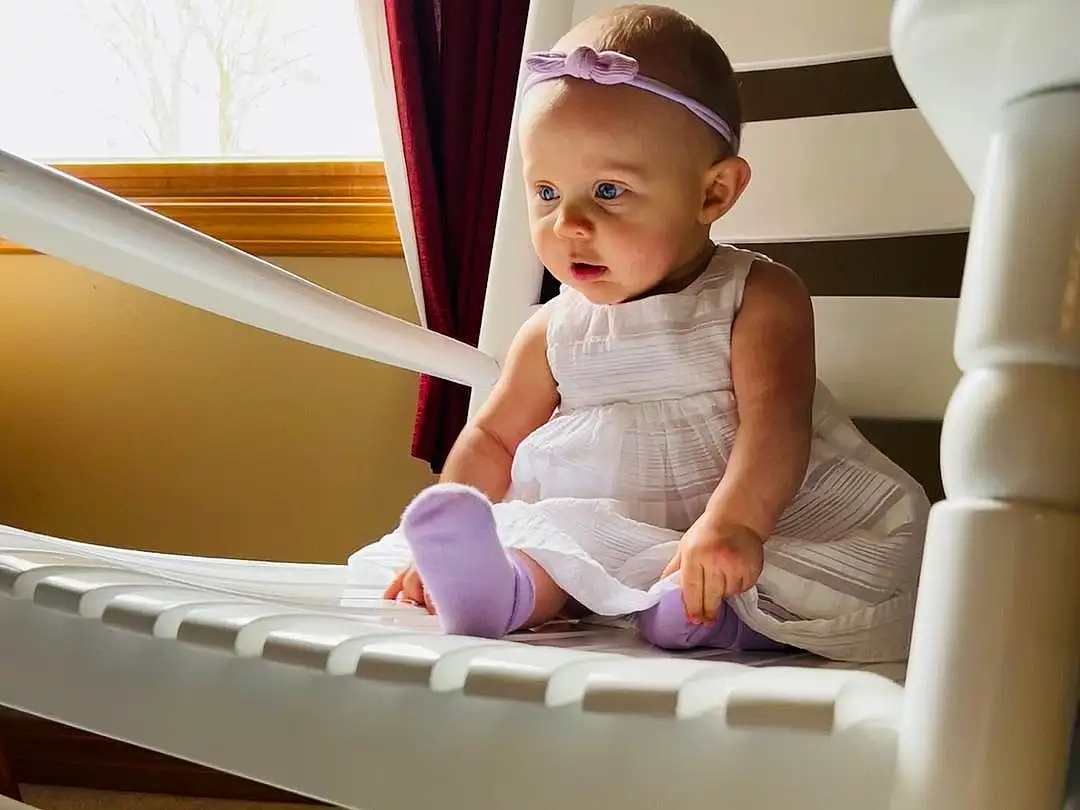 Hand, Arm, Smile, Stairs, Comfort, Baby & Toddler Clothing, Wood, Window, Toddler, Happy, Baby, Child, Room, Sitting, Hardwood, Handrail, T-shirt, Leisure, Curtain, Elbow, Person