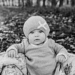 Cheek, Photograph, Facial Expression, People In Nature, Black, Happy, Flash Photography, Black-and-white, Style, Grass, Baby, Cap, Baby & Toddler Clothing, People, Toddler, Black & White, Monochrome, Plant, Child, Sitting, Person, Headwear