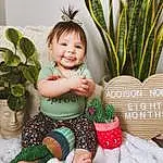 Smile, Plant, Facial Expression, Leaf, Happy, Baby & Toddler Clothing, Grass, Greeting, Christmas Ornament, Terrestrial Plant, Christmas Decoration, Flowerpot, Ornament, People In Nature, Toddler, Child, Event, Baby, Person, Joy