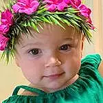 Face, Flower, Chin, Eyes, Plant, Green, Lei, Petal, Iris, Pink, Happy, Baby & Toddler Clothing, Toddler, Headgear, Baby, Headpiece, Beauty, Grass, Magenta, Costume Hat, Person, Headwear