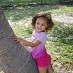 Plant, People In Nature, Smile, Grass, Happy, Dress, Tree, Leisure, Woody Plant, Trunk, Adaptation, Groundcover, Toddler, Fun, Thigh, Landscape, Shorts, Wilderness, Person, Joy
