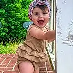 Head, Smile, Hand, Eyes, Plant, Leg, Green, Human Body, Baby & Toddler Clothing, Pink, People In Nature, Finger, Headgear, Fawn, Toddler, Happy, Thigh, Beauty, Knee, Person, Headwear