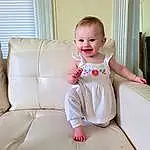 Face, Cheek, Skin, Joint, Smile, Shoulder, Baby & Toddler Clothing, Comfort, Dress, Sleeve, Flash Photography, Finger, Happy, One-piece Garment, Couch, Toddler, Baby, Curtain, Person, Joy