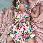 Skin, Joint, Head, Hand, Arm, Plant, Facial Expression, Dress, Leg, Mouth, One-piece Garment, Baby & Toddler Clothing, Human Body, Textile, Sleeve, Pink, Day Dress, Finger, Thigh, Baby