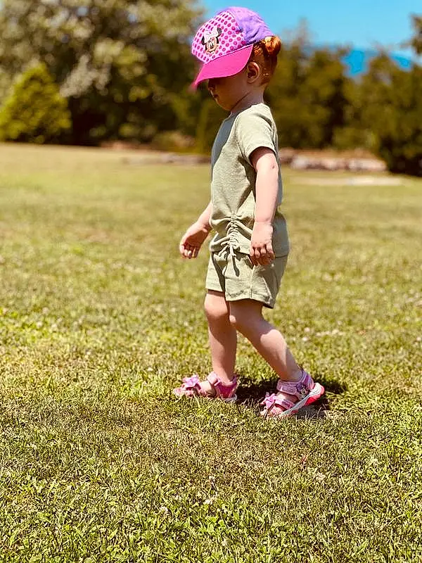 Plant, People In Nature, Hat, Happy, Grass, Pink, Cap, Baby & Toddler Clothing, Grassland, Toddler, Summer, Recreation, Leisure, Sun Hat, Meadow, Baseball Cap, Child, Lawn, Landscape, Person