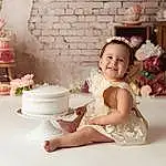 Smile, Dress, Textile, Flash Photography, Happy, Pink, Headgear, Cake, Baby & Toddler Clothing, Toddler, Tableware, Headpiece, Petal, Sugar Cake, Embellishment, Wedding Ceremony Supply, Event, Baby, Icing, Person, Joy