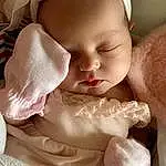 Cheek, Skin, Lip, Eyes, Baby & Toddler Clothing, Textile, Iris, Dress, Pink, Sleeve, Headgear, Baby, Toddler, Beauty, Comfort, Baby Sleeping, Petal, Headpiece, Eyelash