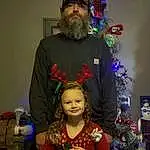 Christmas Tree, Hairstyle, Beard, Standing, Christmas Ornament, Hat, Fun, Smile, Happy, Holiday Ornament, Shipping Box, Christmas Decoration, Event, Tradition, Holiday, Christmas, Room, Ornament, Facial Hair, Tree, Person, Joy, Headwear