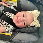 Smile, Skin, Lip, Eyes, Comfort, Textile, Flash Photography, Sleeve, Happy, Automotive Design, Cool, Toddler, Car Seat, Auto Part, Automotive Wheel System, Blond, Child, Pattern, Baby & Toddler Clothing, Person, Joy, Headwear
