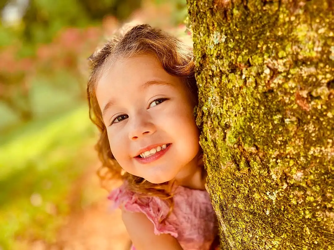 Hair, Lip, Smile, Plant, People In Nature, Flash Photography, Wood, Happy, Iris, Sunlight, Grass, Leisure, Toddler, Tree, Natural Landscape, Trunk, Close-up, Forest, Fun, Brown Hair, Person, Joy
