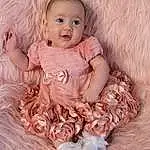 Clothing, Face, Head, Eyes, Smile, Dress, Baby & Toddler Clothing, Textile, Sleeve, Iris, Baby, Headgear, Pink, Happy, Flash Photography, Toddler, Embellishment, Child, Headpiece, Peach, Person