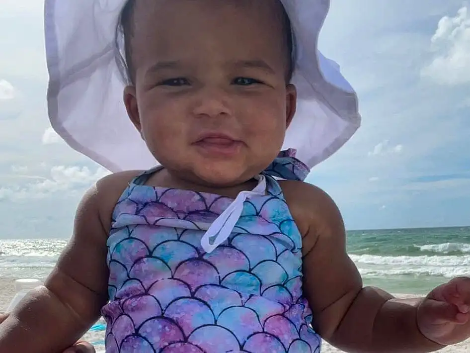 Face, Skin, Head, Sky, Cloud, Photograph, Eyes, Facial Expression, Blue, Mouth, Muscle, Leg, Azure, Beach, Happy, People On Beach, Baby & Toddler Clothing, Pink, Toddler, Person