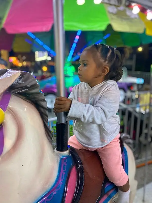 Hairstyle, Facial Expression, Pink, Fun, Happy, Leisure, Public Space, Thigh, Recreation, Child, Black Hair, Toddler, Magenta, Event, Human Leg, Trunk, City, Amusement Ride, Person