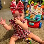 Toy, Happy, Grass, Fawn, Fun, Wheel, Party Supply, Toddler, Leisure, Child, Event, Play, Doll, Magenta, Holiday, Carmine, Fashion Accessory, Sitting, Toy Vehicle, Baby Products, Person, Headwear
