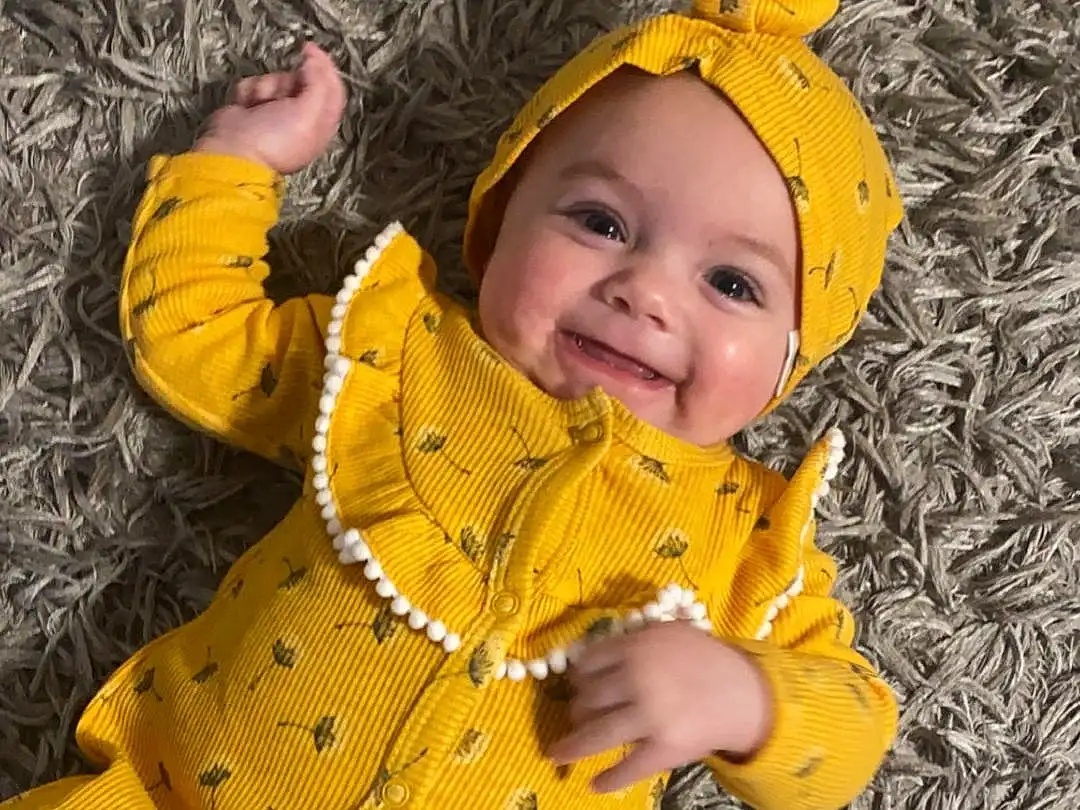 Face, Smile, Outerwear, Plant, Eyes, People In Nature, Leaf, Human Body, Baby & Toddler Clothing, Wood, Happy, Yellow, Gesture, Baby, Tree, Grass, Woody Plant, Toddler, Adaptation, Jacket, Person, Joy, Headwear