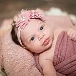 Face, Skin, Lip, Eyebrow, Eyes, Smile, Plant, Flash Photography, Baby, Petal, Iris, Happy, Baby & Toddler Clothing, Pink, Flower, Headgear, Headpiece, Grass, Wood, Toddler, Person