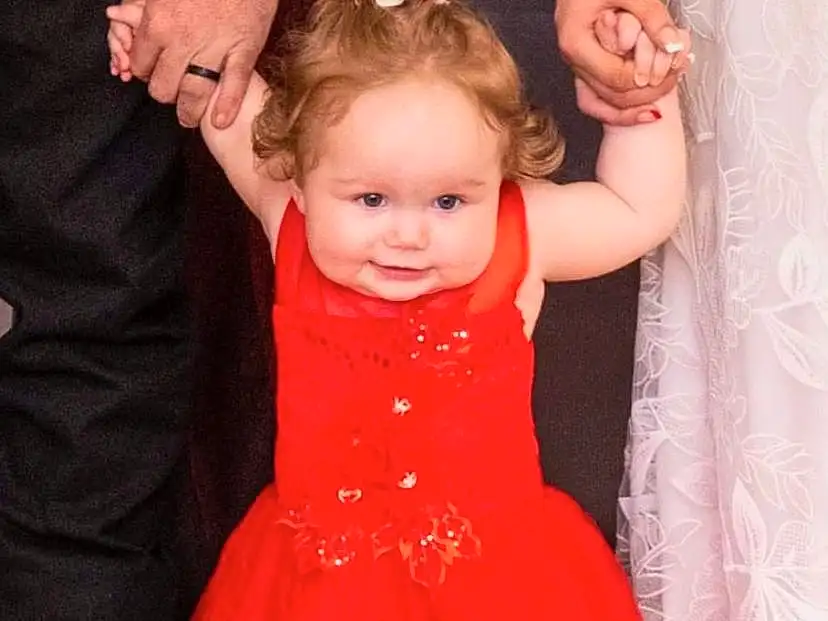 Hair, Face, Skin, Head, Hand, Smile, Arm, Shoulder, One-piece Garment, Dress, Human Body, Textile, Baby & Toddler Clothing, Sleeve, Standing, Happy, Pink, Gesture, Baby, Bridal Party Dress, Person