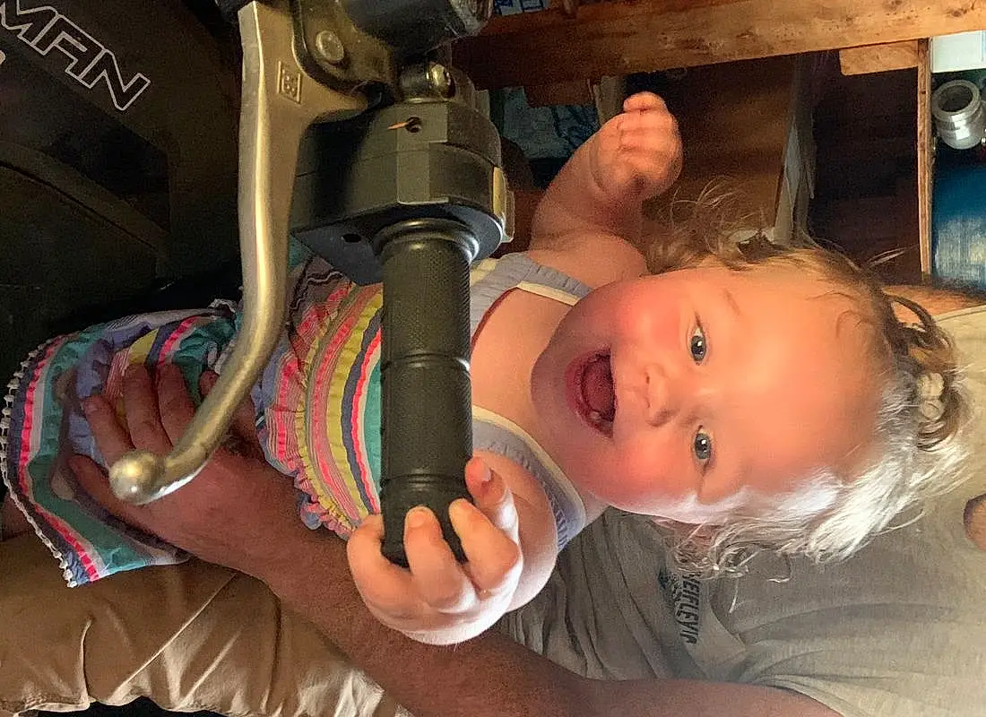 Nose, Skin, Eyes, Ear, Smile, Iris, Finger, Toddler, People, Fun, Child, Chair, Audio Equipment, Wood, Sitting, Baby Products, Machine, Room, Vacation, Baby, Person
