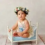 Clothing, Skin, Eyes, Leg, Baby & Toddler Clothing, Flash Photography, Baby, Happy, Flower, Chair, Headpiece, Toddler, Wood, Headband, Jewellery, Child, Sitting, Baby Products, Fashion Accessory, Thigh, Person
