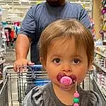 Clothing, Nose, Skin, Lip, Hairstyle, Food, Mouth, Shelf, Iris, Gesture, Natural Foods, Happy, Public Space, Cool, Toddler, Fun, Fruit, Baby, Leisure, Person, Joy