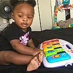 Hand, Hearing, Sharing, Table, Toy, Toddler, Chair, T-shirt, Fun, Audio Equipment, Headphones, Event, Child, Gadget, Room, Play, Recreation, Sitting, Toy Vehicle, Circle, Person