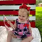 Photograph, Eyes, Leg, Dress, Baby & Toddler Clothing, Pink, Red, Happy, Thigh, Toddler, Embellishment, Child, Grass, Day Dress, Pattern, Human Leg, Blond, Sitting, Magenta, Chair, Person, Joy