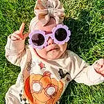 Glasses, Vision Care, Goggles, Sunglasses, Baby & Toddler Clothing, Eyewear, Plant, Sleeve, People In Nature, Happy, Pink, Grass, Finger, Fawn, Toddler, Baby, Personal Protective Equipment, Pattern, Fun, Recreation, Person, Headwear