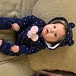 Cheek, Eyes, Comfort, Sleeve, Textile, Baby & Toddler Clothing, Gesture, Toddler, Child, Pattern, Baby, Happy, Sitting, Wood, Baby Products, Toy, Ball, Doll, Linens, Thumb, Person