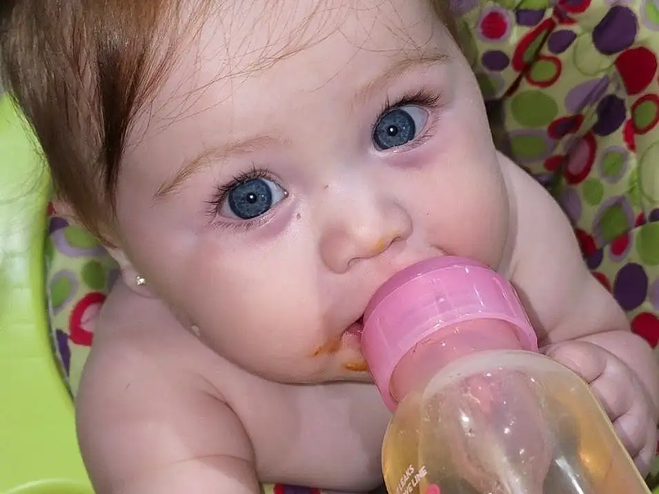Nose, Cheek, Skin, Lip, Baby Bottle, Facial Expression, Mouth, Eyelash, Drinkware, Baby, Iris, Bottle, Plastic Bottle, Finger, Pink, Baby Grabbing For Something, Toddler, Happy, Baby Playing With Toys, Person