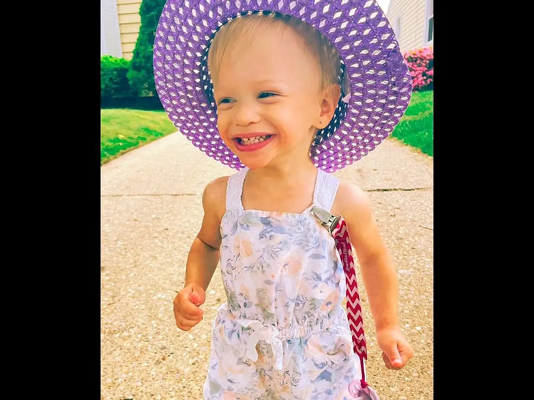 Clothing, Face, Head, Smile, Outerwear, Eyes, Facial Expression, White, Dress, Hat, Baby & Toddler Clothing, Human Body, Purple, Happy, Sleeve, Costume Hat, Pink, Sun Hat, Cool, Toddler, Person, Joy