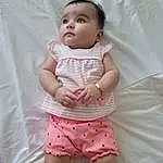 Face, Cheek, Skin, Lip, Hairstyle, Eyes, Stomach, Baby & Toddler Clothing, Sleeve, Textile, Baby, Dress, Iris, Gesture, Pink, Finger, Thigh, Waist, Comfort, Toddler, Person