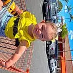 Car, Tire, Wheel, Vehicle, Sky, Smile, Yellow, Shorts, Fun, Leisure, Vehicle Door, Toddler, Sunglasses, Vroom Vroom, Child, Recreation, T-shirt, Automotive Exterior, Personal Protective Equipment, Play, Person