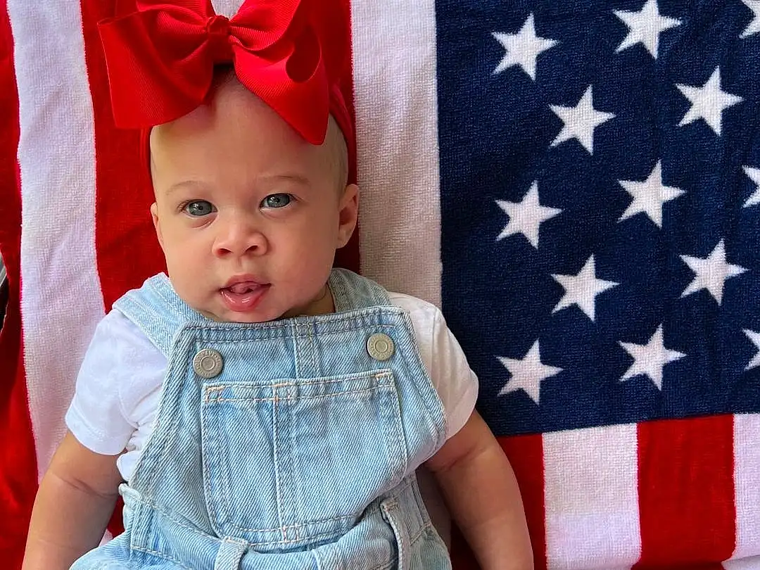 Face, White, Blue, Baby & Toddler Clothing, Textile, Sleeve, Flag Of The United States, Dress, Happy, Red, Toddler, Thigh, Pattern, Cap, Baby, Costume Hat, Electric Blue, Flag Day (usa), Flag, Event, Person