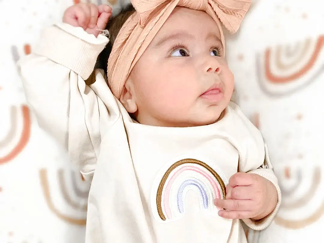 Cheek, Outerwear, Eyes, White, Baby & Toddler Clothing, Human Body, Drinkware, Sleeve, Textile, Happy, Baby, Headgear, Toddler, Cap, Child, Costume Hat, Comfort, Event, Fictional Character, Fashion Accessory, Person, Headwear