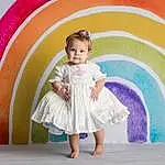 Skin, Facial Expression, Dress, Fashion, Textile, Happy, Standing, Pink, Baby & Toddler Clothing, Toddler, Leisure, Headgear, Fun, Recreation, Child, Magenta, Art, Event, Person