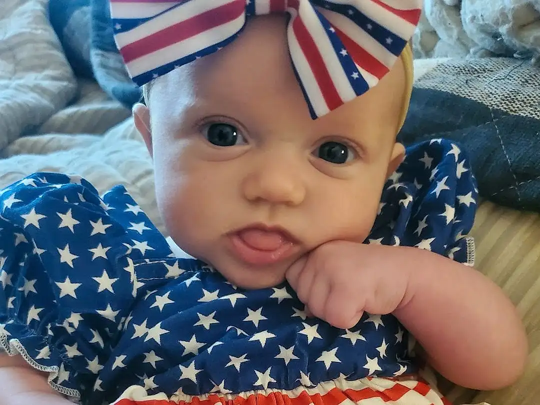 Human Body, Textile, Gesture, Sleeve, Baby & Toddler Clothing, Toddler, Happy, Flag Of The United States, Tree, Comfort, Baby, Grass, Child, Pattern, Elbow, Fun, Sitting, Hat, Nail, Linens, Person, Headwear