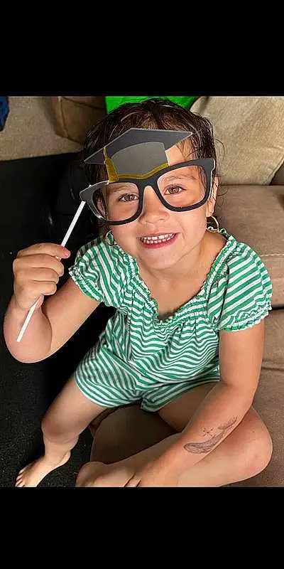 Smile, Mouth, Vision Care, Eyewear, Flash Photography, Thigh, Happy, Leisure, Personal Protective Equipment, T-shirt, Chest, Human Leg, Audio Equipment, Fun, Child, Toddler, Fashion Accessory, Sitting, Recreation, Headphones, Person, Joy, Headwear
