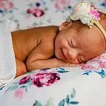 Skin, Comfort, Flower, Textile, Baby, Plant, Happy, Toddler, Baby Sleeping, Linens, Child, Pattern, Headpiece, Headband, Jewellery, Bedding, Bedtime, Fashion Accessory, Nap, Bed Sheet, Person