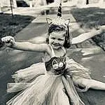 White, Smile, Ballerina tutu, Flash Photography, Dance, Happy, Dress, Style, Headpiece, Feather, Entertainment, Performing Arts, Toddler, Monochrome, Fun, Art, Event, Choreography, Grass, Road, Person, Joy