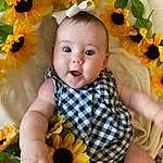 Face, Flower, Plant, Hand, Hairstyle, Photograph, Facial Expression, Leaf, Baby & Toddler Clothing, Botany, Orange, Happy, Textile, Yellow, Petal, Iris, Baby, Dress, Person