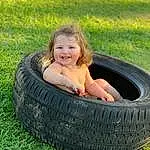 Tire, Plant, Wheel, Smile, Automotive Tire, People In Nature, Tread, Synthetic Rubber, Leisure, Automotive Wheel System, Grass, Fun, Automotive Design, Rim, Toddler, Happy, Lawn, Tire Care, Person, Joy