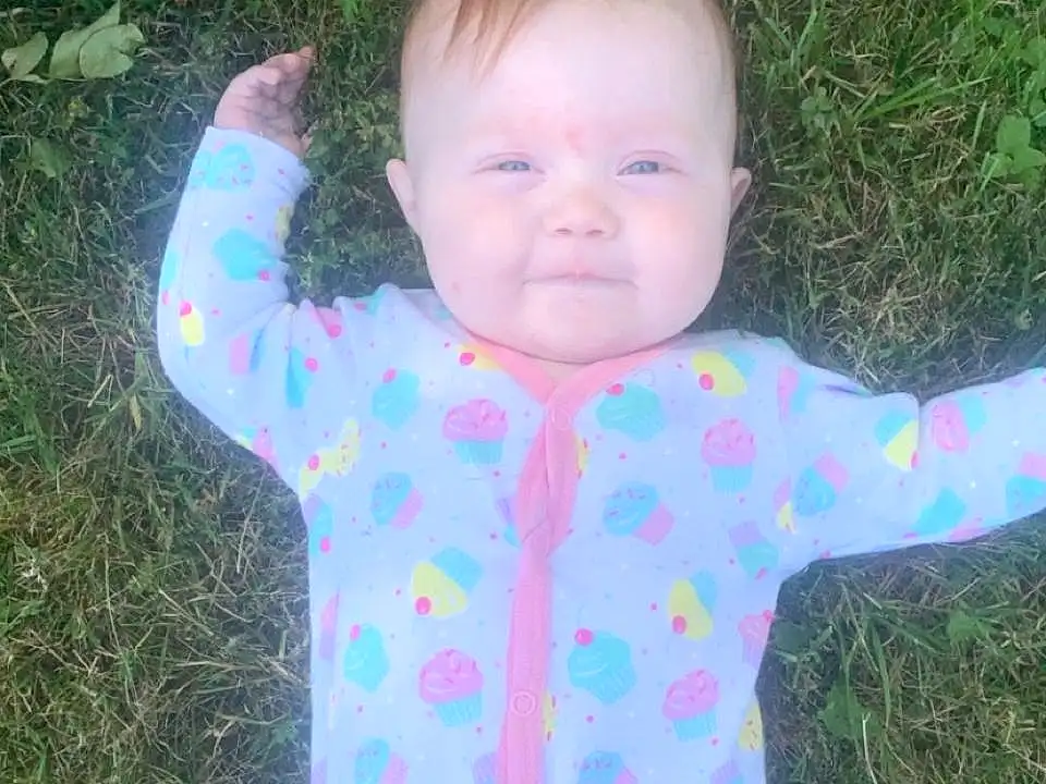 Face, Cheek, Head, Arm, Eyes, Smile, Baby & Toddler Clothing, Human Body, Sleeve, Gesture, People In Nature, Pink, Happy, Grass, Baby, Toddler, Thumb, Child, Pattern, Infant Bodysuit, Person