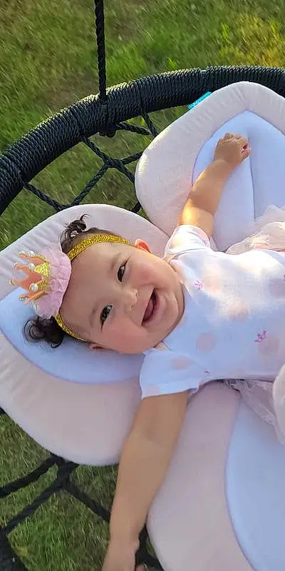 Face, Cheek, Skin, Head, Lip, Hairstyle, Smile, Baby, Human Body, Baby & Toddler Clothing, Textile, Happy, Headgear, Pink, Grass, Toddler, Fun, Comfort, Child, Leisure, Person, Joy, Headwear
