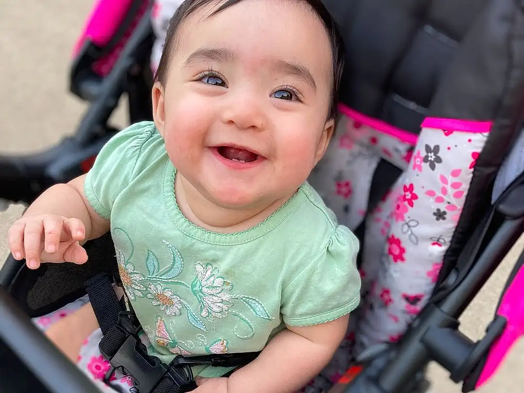 Cheek, Skin, Head, Hand, Hairstyle, Smile, Arm, Eyes, Facial Expression, Baby Carriage, Baby, Pink, Vroom Vroom, Finger, Happy, Vehicle, Toddler, Auto Part, Fun, Person, Joy