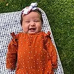 Comfort, Couch, Textile, Orange, Red, Grass, Linens, Baby & Toddler Clothing, Baby, Studio Couch, Wood, People In Nature, Pattern, Bedding, Toddler, Child, Leisure, Sitting, Pillow, Peach, Person, Headwear