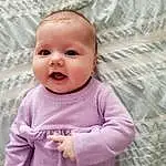 Clothing, Face, Nose, Cheek, Skin, Head, Smile, Lip, Chin, Outerwear, Hairstyle, Eyes, Baby, Baby & Toddler Clothing, Purple, Sleeve, Happy, Gesture, Pink, Toddler, Person