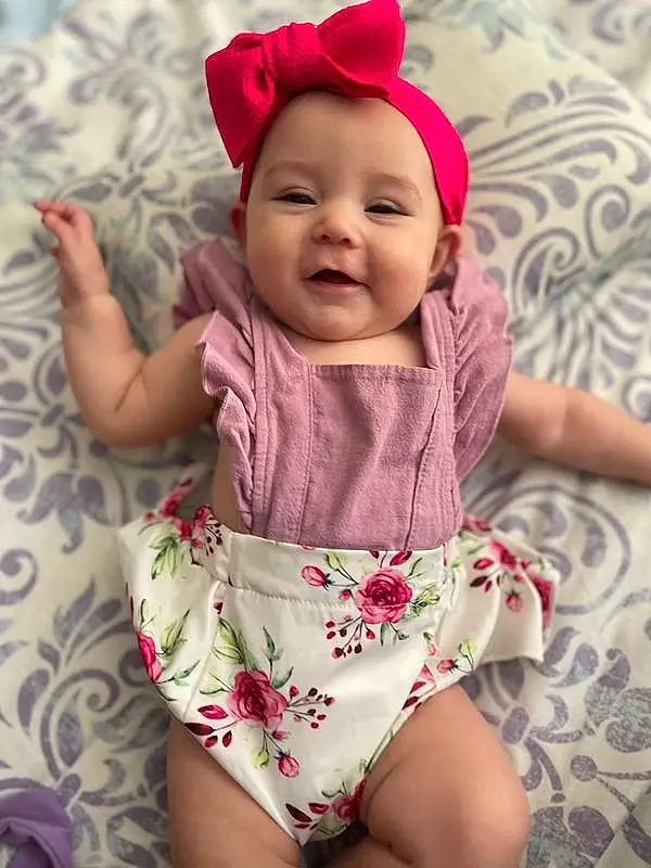 Face, Cheek, Skin, Smile, Head, Lip, Chin, Eyes, Mouth, Baby & Toddler Clothing, Human Body, Happy, Purple, Baby, Sleeve, Textile, Comfort, Pink, Dress, Finger, Person